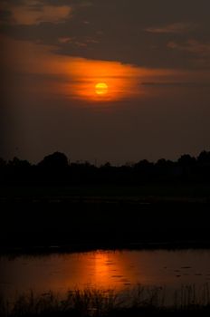 Dramatic  sunset landscape with dark  sky, silhouettes of trees and lake. sky of lake landscape