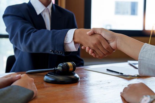 Businessman shaking hands to seal a deal with his partner lawyers or attorneys discussing a contract agreement