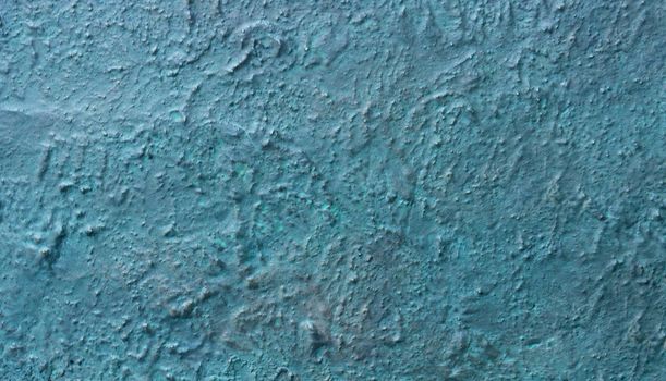 Unevenly plastered and painted blue wall.