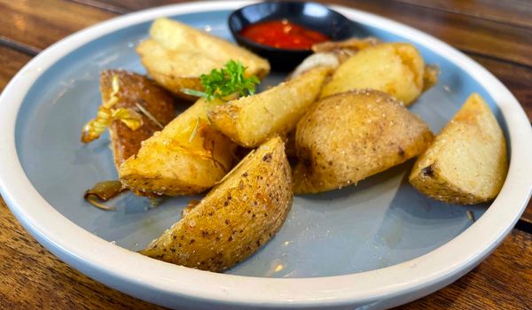 Baked potato wedges with shredded onion and herbs and tomato sauce platted homemade organic vegetable vegan vegetarian potato wedges snack food meal