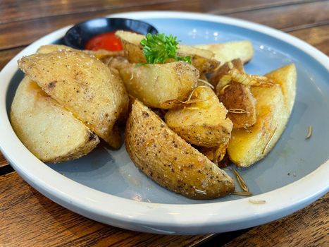 Baked potato wedges with shredded onion and herbs and tomato sauce platted homemade organic vegetable vegan vegetarian potato wedges snack food meal