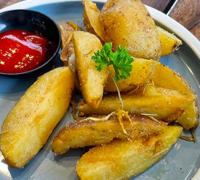 Baked potato wedges with shredded onion and herbs and tomato sauce platted homemade organic vegetable vegan vegetarian potato wedges snack food meal