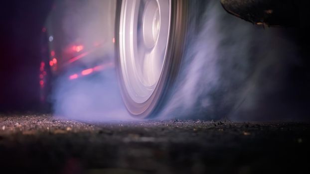 Drag racing car burning tire at starting line in race track