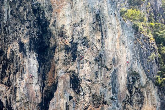 Three Rock climbers on Railay cliff, one of the most popular rock climbing locations in Asia.