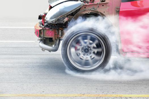 race car burns rubber off its tires in preparation for the race