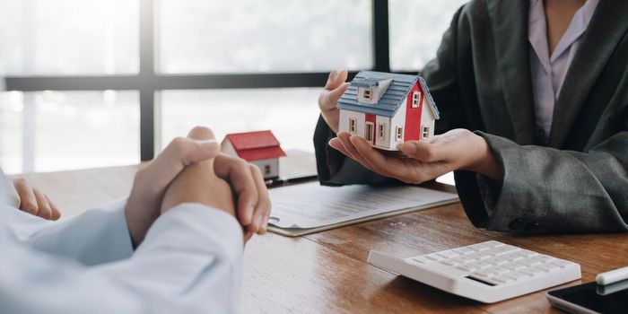 Real estate agent talked about the terms of the home purchase agreement and asked the customer to sign the documents to make the contract legally, Home sales and home insurance concept..