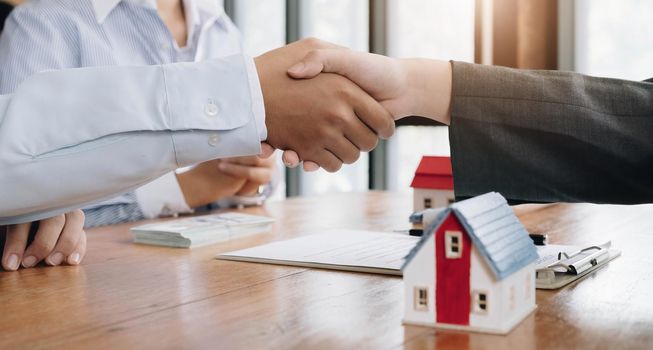 Successful agreement , estate,home buying contract concept, buyer shaking hand with bank empoyees after finishing signing contract in office.