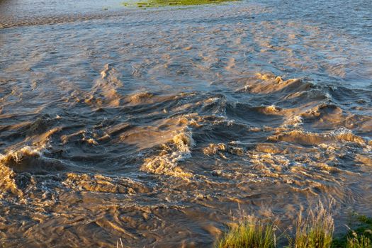 Stormy river flooding the river with muddy water and high waves