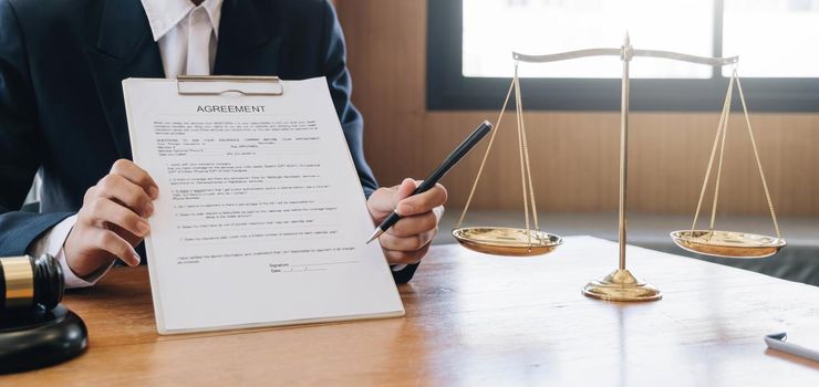 Male lawyer working with contract papers and wooden gavel on tabel in courtroom. justice and law ,attorney, court judge, concept..