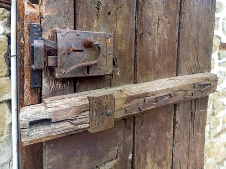 Old metal and wood lock of a wooden door. Close up