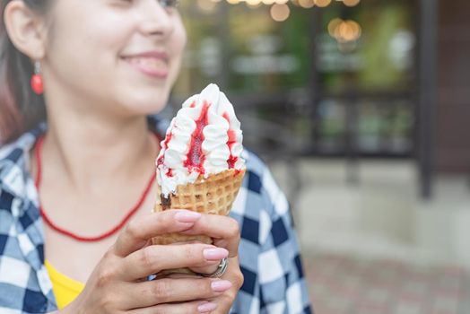Attractive young woman in summer clothes and sunglasseseating ice cream at street