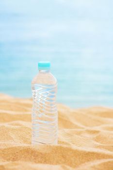 drinks, summertime and environment concept - bottle of water on the beach, elegant visuals