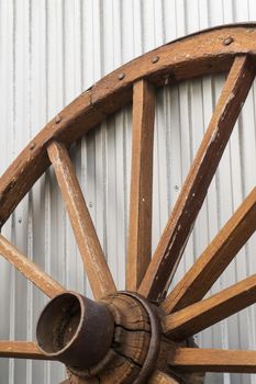 Antique wooden wheel on metallic background close up