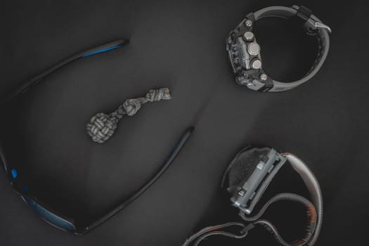 Flatlay from a bunch of Outdoor equipment,  on a dark background.