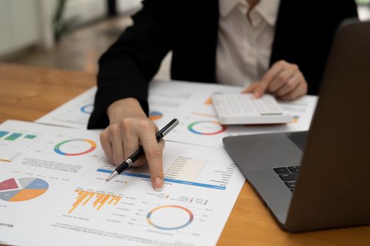 Business woman counting on calculator and holding documents in hands closeup. Bookkeeping concept.
