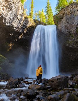 Moul Falls Canada is a Beautiful waterfall in Canada, couple of visits to Moul Falls, the most famous waterfall in Wells Gray Provincial Park. a couple of men and women standing by a waterfall