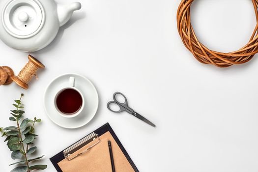 Still life with tea cup and the contents of a workspace composed. Different objects on white table. Flat lay. Top view. Copy space