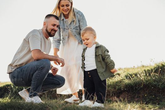 Portrait of Happy Young Family Outdoors, Father and Mother with Their Little Son Having Fun Time