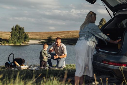 Happy Family Weekend Concept, Mother and Father with Toddler Son Enjoying Picnic Outdoors on Road Car Trip