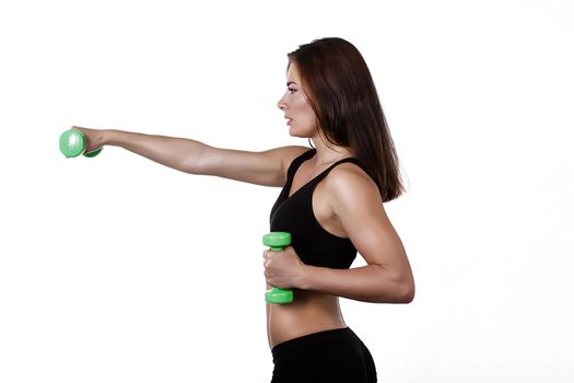 Fitness happy girl with dumbbells on a white background in black clothes in profile