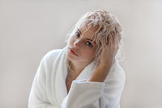 Portrait of a beautiful attractive sexy and sensuality young adult pretty blonde woman after bath relaxing in a bathrobe