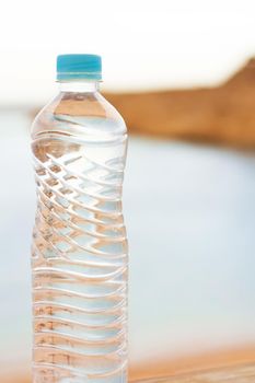 drinks, summertime and environment concept - bottle of water on the beach, elegant visuals