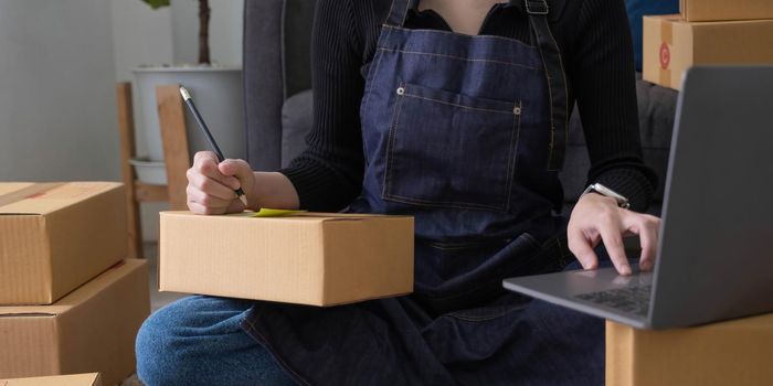 Starting small businesses SME owners female entrepreneurs Write the address on receipt box and check online orders to prepare to pack the boxes, sell to customers, sme business ideas online..