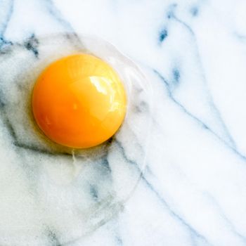 egg yolk on marble - recipe ingredients and homemade cooking styled concept