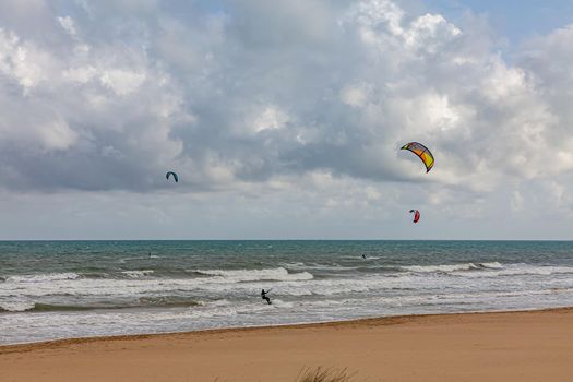 Evening view on small sand dune with green grass. Sandy beach at sea coast. Blue sky with white clouds. Sunset time.