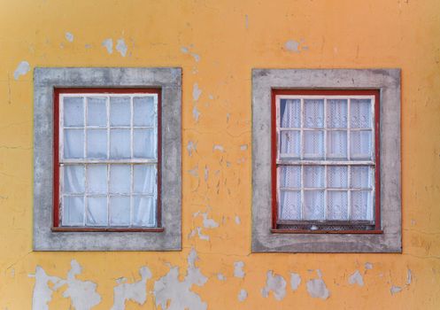Old dirty window on the yellow wall