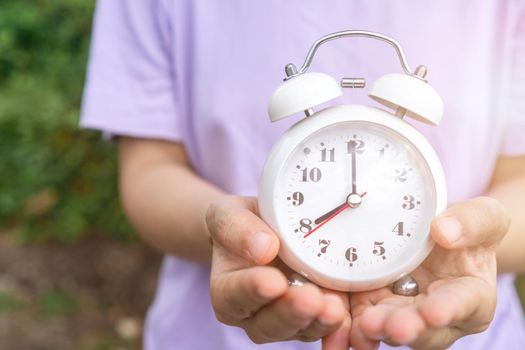 Selective focus of alarm clock with nature bokeh background. lifestyle  productive life concept.