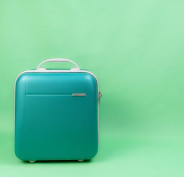 Green luggage for travel on green background