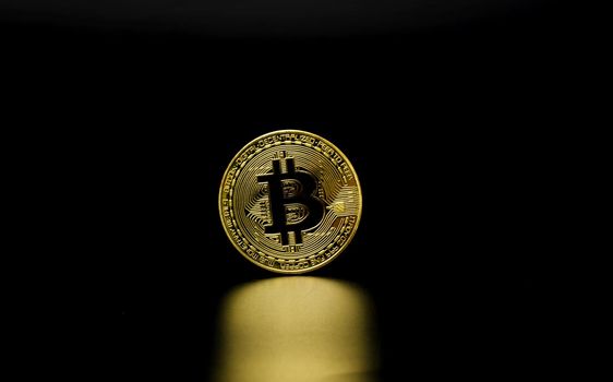 Gold Bitcoin on black background. Cryptocurrency coin