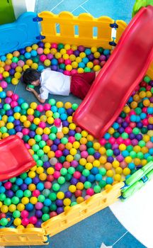 Lonely student in the play area with colorful plastic ball and slider