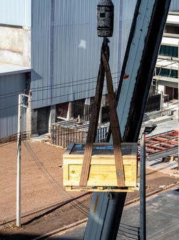 The crane carrying a wooden box of the radioactivity instrument holder transportation wooden box