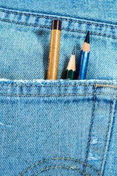 Different type of three pencils in the pocket of denim blue jean