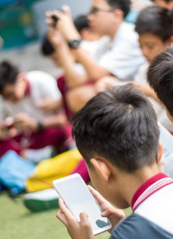 BANGKOK THAILAND - April 19,2018 Many Serious children playing on smartphone, Children playing on smartphone during the brake time in school