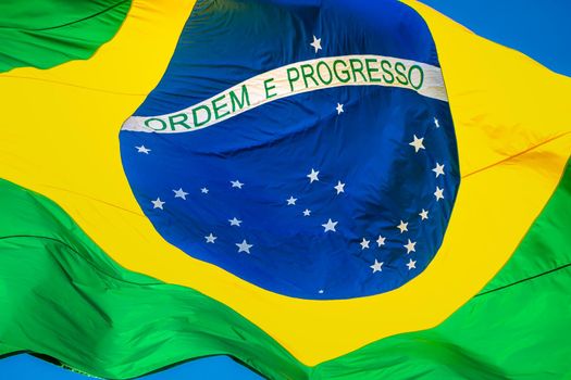 National flag of Brazil winding on blue sky in Brasilia, South America