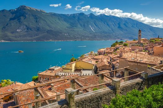 Idyllic Lake Garda above Limone sul Garda old town with motorboat, Italian alps