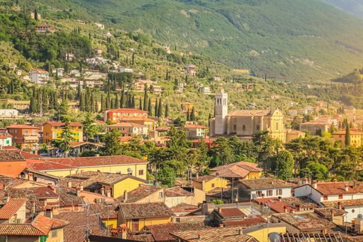 Above Malcesine old town with church and mountain range at golden sunset