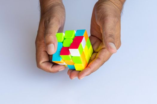 Male hands holding a rubik's cube on a white isolated background