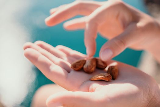 Unrecognizable caucasian woman eating young milky almond nuts. Healthy vegan food