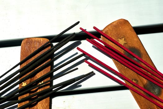 a gum, spice, or other substance that is burned for the sweet smell it produces. Red black incense sticks.