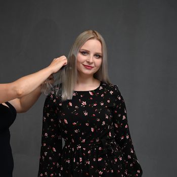 Beautiful hairstyle of young blondy woman after dyeing hair and making highlights