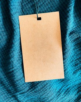 Blank fashion label tag, sale price card on luxury fabric background, shopping and retail concept