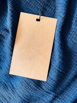 Blank fashion label tag, sale price card on luxury fabric background, shopping and retail concept