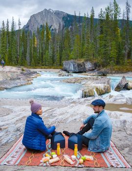 Emerald lake Yoho national park Canada British Colombia. beautiful lake in the Canadian Rockies during the Autumn fall season. Couple men and women picnic at Natural Bridge Lower Falls