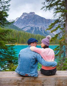 Emerald lake Yoho national park Canada British Colombia. beautiful lake in the Canadian Rockies during the Autumn fall season, couple men and women sitting by the lake looking out over the mountains