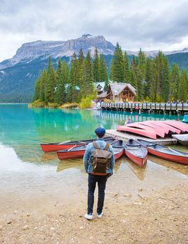 Emerald lake Yoho national park Canada British Colombia. beautiful lake in the Canadian Rockies during the Autumn fall season. Young men with bag standing by the lake