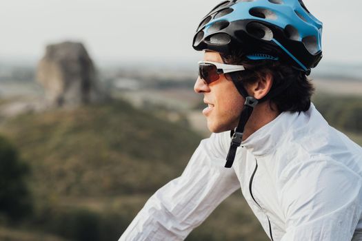 Close Up Portrait of Professional Male Cyclist, Adult Man Wearing Helmet and Protection Sport Glasses Looking Away, Copy Space